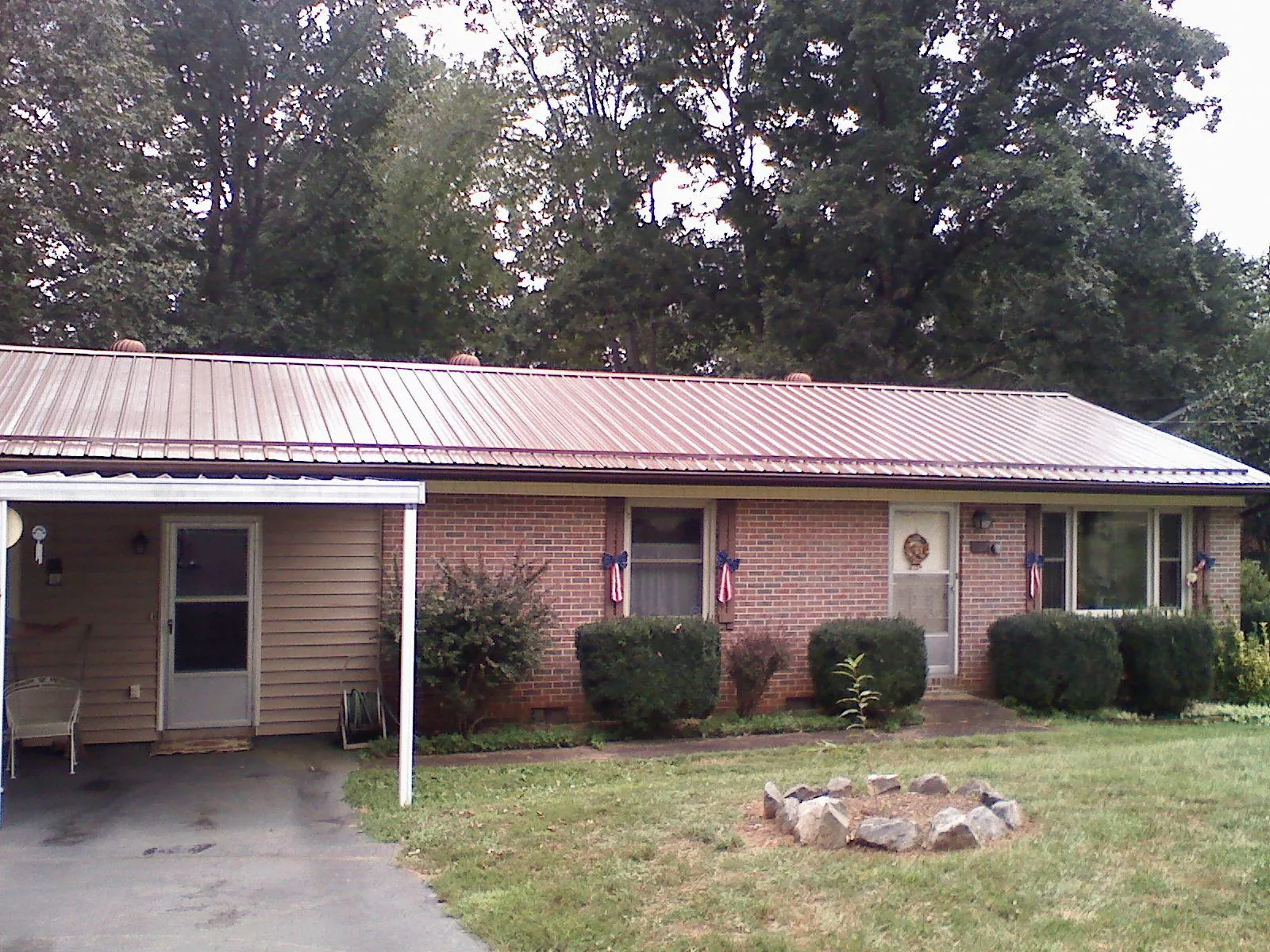 Bronze metal roof and carport on a brick ranch home — Roof Repair work by our crew in Newtonville